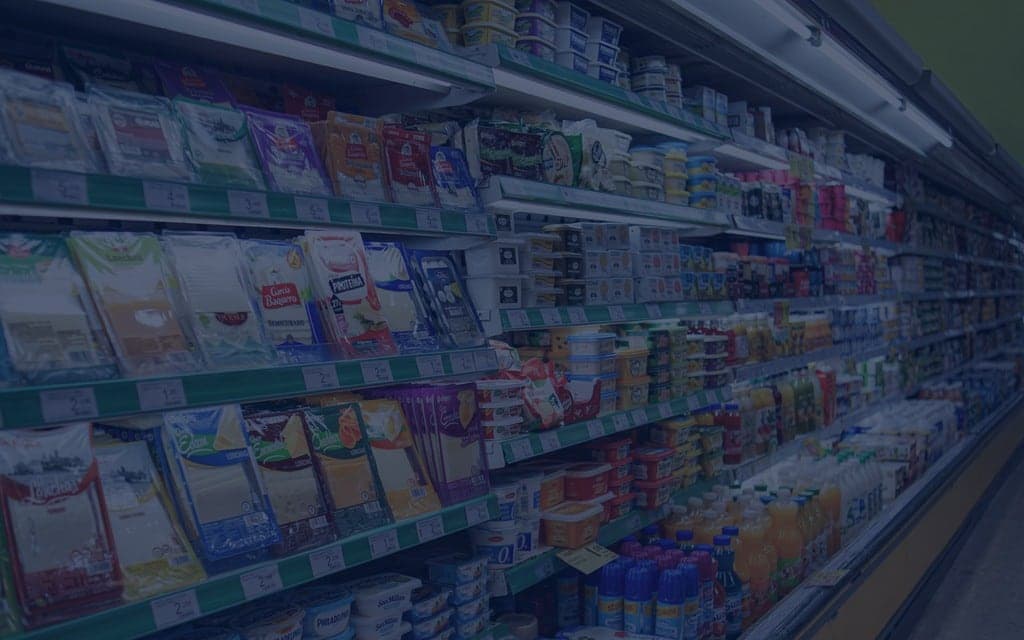 Supermarket aisle with dairy products and refrigerated items on shelves